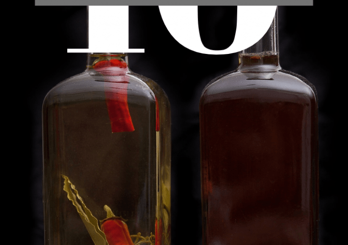 Two vinegar bottles on a black backgroun.