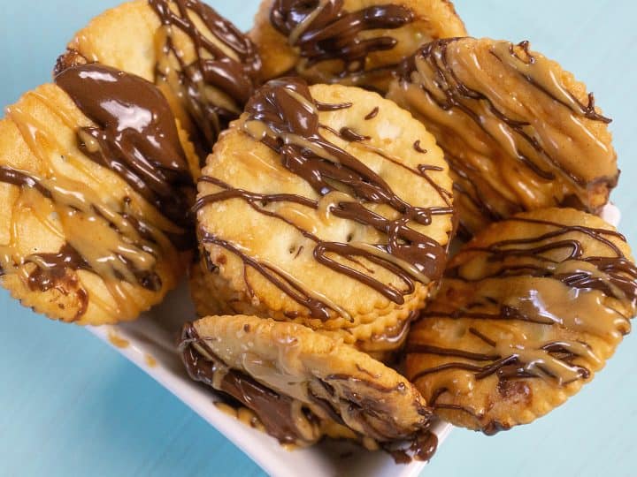 Ritz crackers with peanut butter and chocolate drizzled on them.