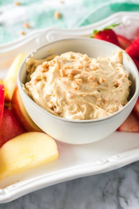 Toffee fruit dip in a white bowl and apples. 