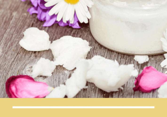 Title photo with a mason jar of coconut oil surrounded by fresh flower petals on a gray background.