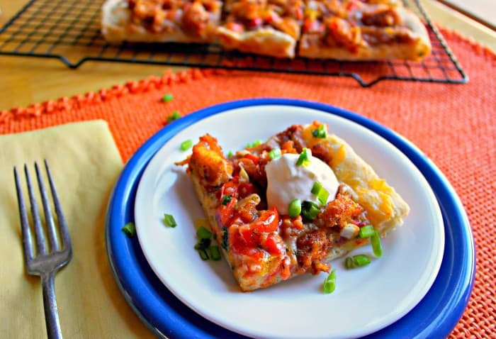 This Mexican Pizza comes together quickly with diced Tyson chicken strips, pizza dough, cheese, refried beans for topping and taco sauce.  Kid approved! - Farmers Wife Rambles