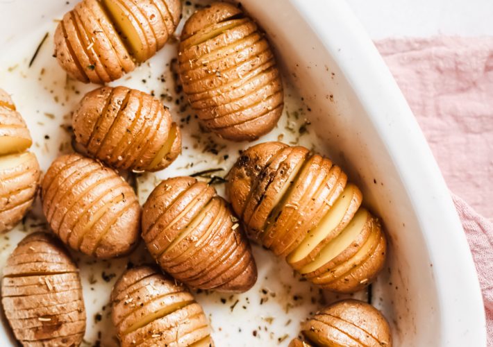 Rosemary Butter Hasselback Potatoes in a white baking dish.